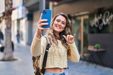 Young woman tourist making selfie by the smartphone at street