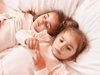 Obraz na płótnie Canvas Two kids lying on bed at bedroom