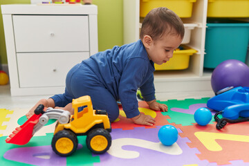 Naklejka premium Adorable hispanic toddler crawling on floor at home