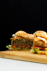Burger cheese with potato in wooden table and black backgournd 