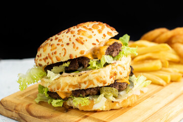 Burger cheese with potato in wooden table and black backgournd 