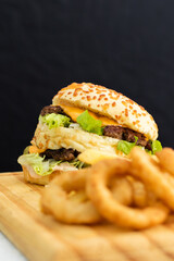 Burger cheese with potato in wooden table and black backgournd 