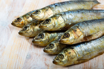Obraz premium Closeup of salted sardines on wooden surface. Food background..