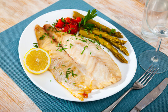 Baked perch fillet served with marinated asparagus and lemon
