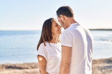 Obraz premium Middle age man and woman couple standing together at seaside