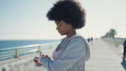 African american woman using stopwatch standing at seaside © Krakenimages.com
