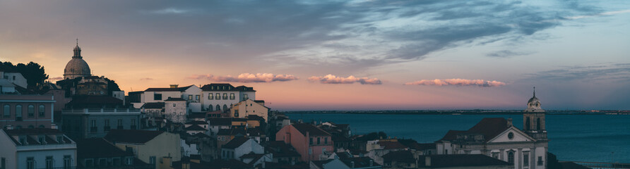A panoramic view of an antique and typical Lisbon city with modest housing, churches, and the...