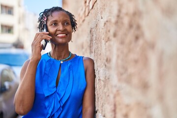 Middle age african american woman smiling confident talking on the smartphone at street