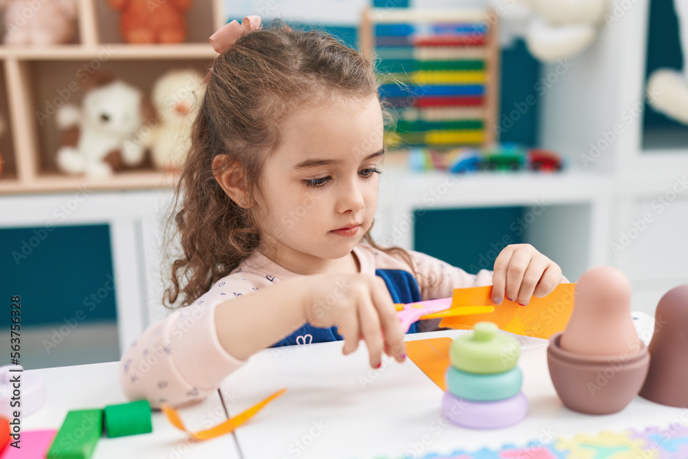 Poster adorable blonde girl student cutting paper at kindergarten