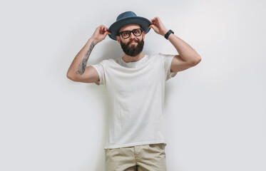 Young bearded hipster guy wearing white blank t shirt with copy space for your text or logo. Mockup for design