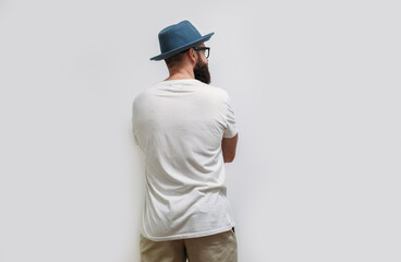 Young bearded hipster guy wearing white blank t shirt with copy space for your text or logo. Mockup...