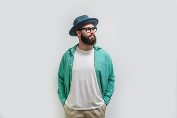 Young bearded hipster guy wearing white blank t shirt with copy space for your text or logo. Mockup...