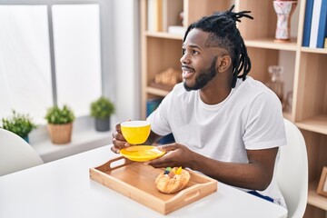 Fototapeta na wymiar African american woman having breakfast sitting on table at home