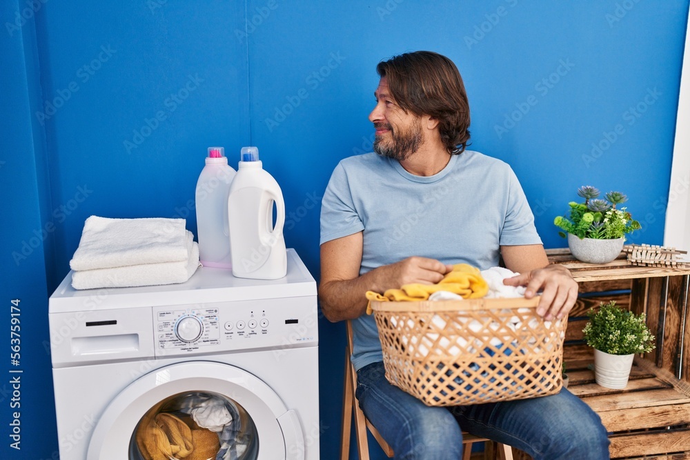 Sticker handsome middle age man waiting for laundry looking to side, relax profile pose with natural face wi