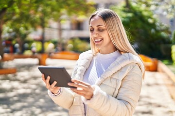 Fototapeta premium Young woman smiling confident watching video on touchpad at park