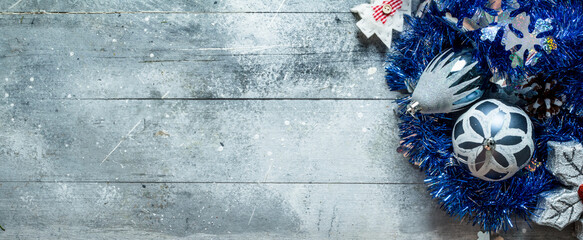 Christmas decorations with blue tinsel and a pine cone.
