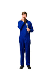 Young adult redhead mechanic man full body isolated biting fingernails, nervous and very anxious.