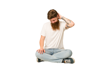 Young adult redhead with a long beard sitting on the floor isolated suffering neck pain due to sedentary lifestyle.