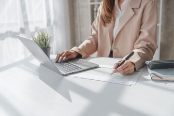 Close up entrepreneur busy woman in her private office working audit and calculating expense financial annual financial report balance sheet statement, checking inspection tax calculation