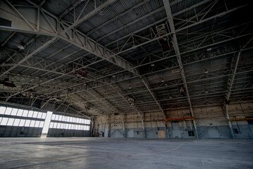 Abandoned airplane hanger with large, steel rafters and trusses