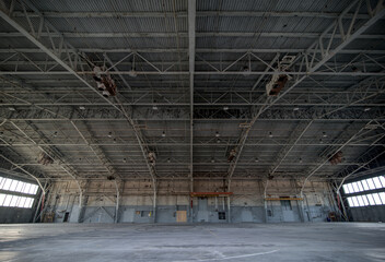 Abandoned airplane hanger with large, steel rafters and trusses