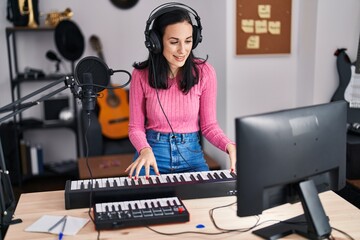 Young caucasian woman musician singing song playing piano at music studio