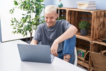 Young caucasian man using laptop sitting on table at home