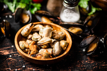 Pickled mussels in a wooden plate on the table. 