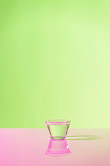 Glass with water on green background