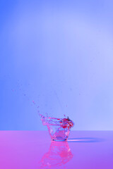 Strawberry drink explosion with purple and lilac lights in studio