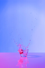 Strawberry drink explosion with purple and lilac lights in studio