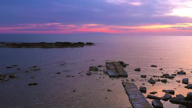 antico porto greco romano con la bassa marea, tramonto con cielo rosa, spiaggia di Torre Ovo, Torricella - Taranto, Salento, Puglia, Italy vista aerea dal drone