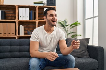 Fototapeta premium Young hispanic man having mental therapy sitting on sofa at psychology center