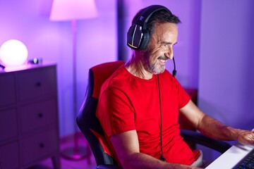 Middle age man streamer playing video game using computer at gaming room © Krakenimages.com