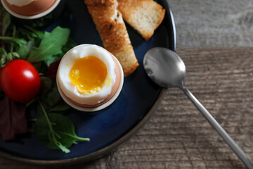 Delicious breakfast with soft boiled eggs served on wooden table, closeup