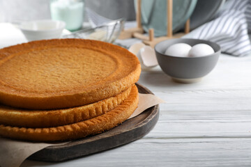 Delicious homemade sponge cakes on white wooden table, closeup. Space for text