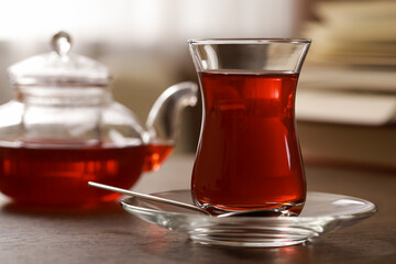 Glass of traditional Turkish tea on wooden table, closeup. Space for text