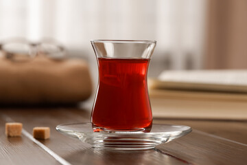 Glass of traditional Turkish tea on wooden table, closeup