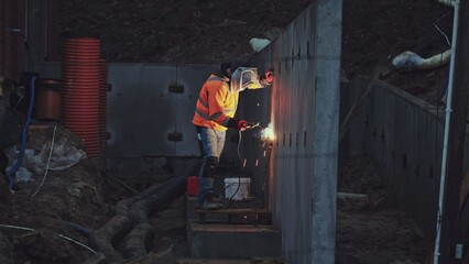 Fototapeta na wymiar Skilled Construction Site Contractor Worker in Protective Wear Operating Electric Arc Welder