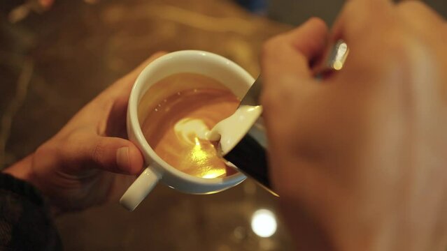 Close Up Asian Man Barista Hand Pouring Froth Milk In Espresso Coffee In Coffee Cup Making Coffee Latte Art Serve To Customer. Small Business Cafe Restaurant Owner And Part Time Job Working Concept.