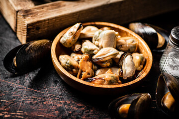 Pickled mussels in a wooden plate on the table. 