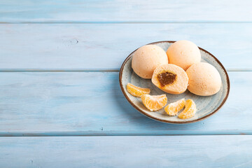 Japanese rice sweet buns mochi filled with tangerine jam on a blue wooden. side view, copy space.