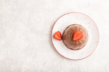 Chocolate jelly with strawberry on gray concrete, top view, copy space.