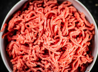 Bowl on the table with fresh minced meat. 