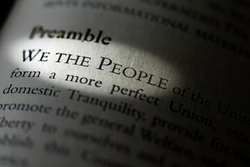The Preamble of the US constitution in textbook highlighting We the People