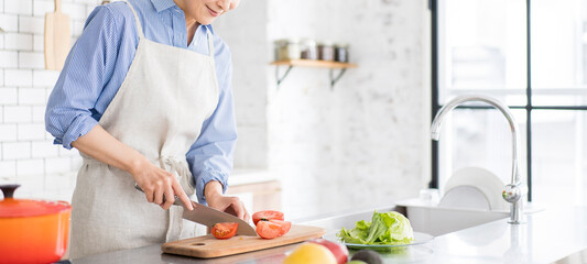 食事の支度、明るく広いキッチンで野菜を切る