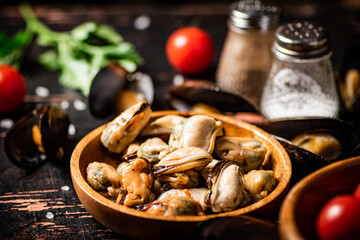 Fototapeta premium Pickled mussels in a wooden plate on the table. 