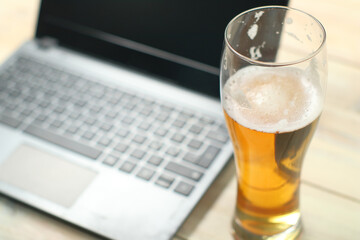 a full mug of beer on the background of a laptop