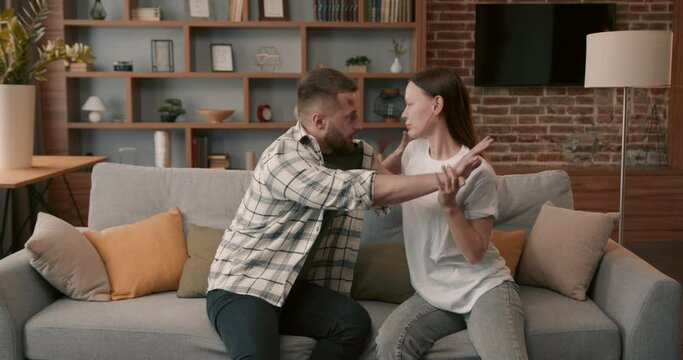 Agressive married man and woman fighting at home