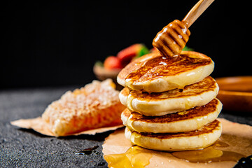 Homemade pancakes with honey on the table. 